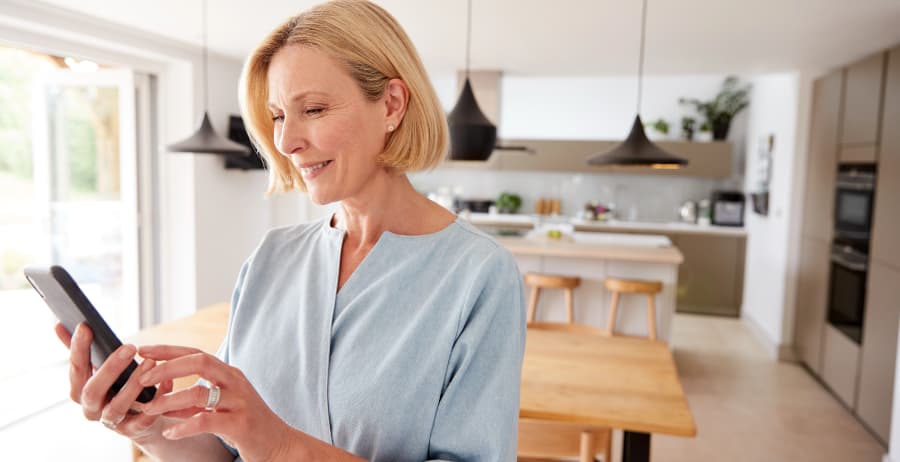 Homeowner using a cell phone in a room filled with sunlight